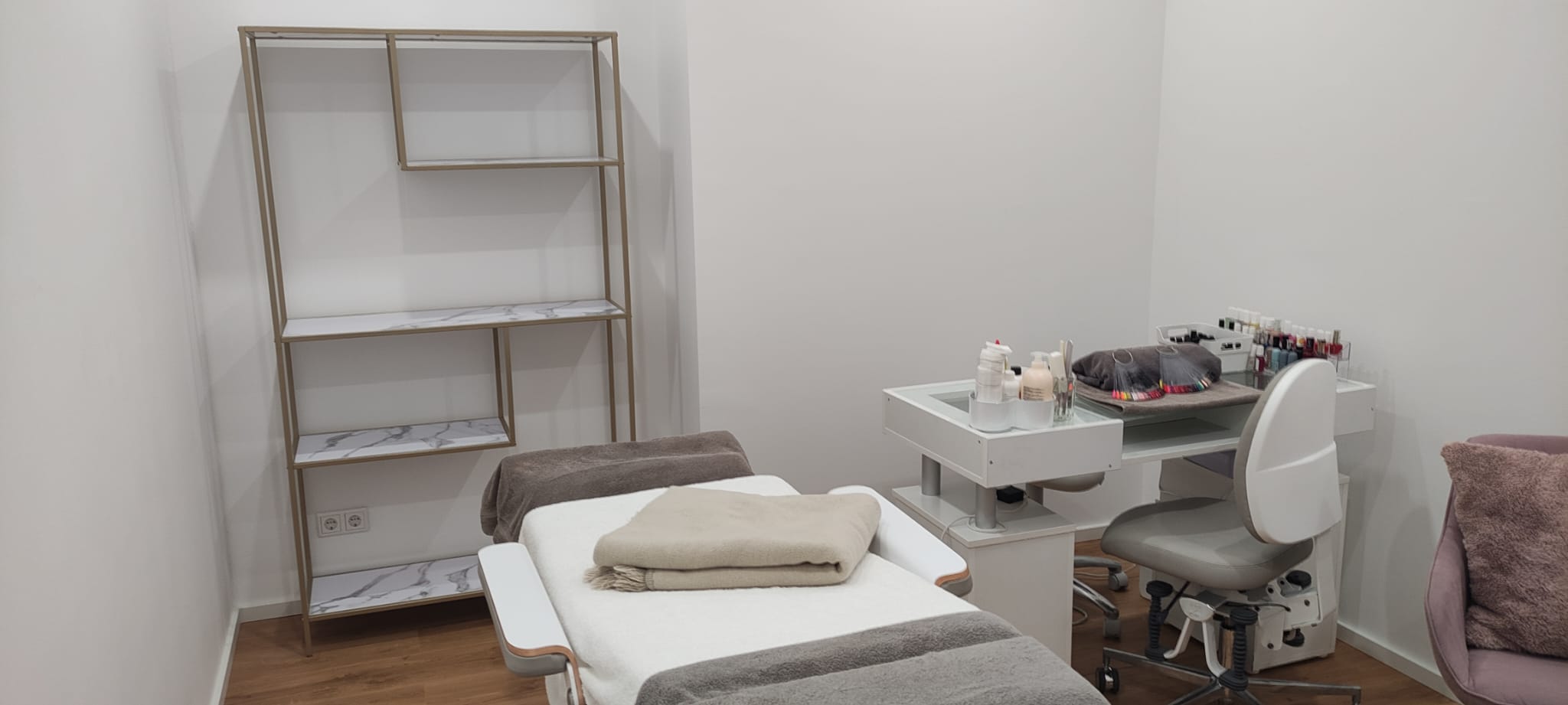 Behandlungsraum mit Liege, Arbeitshocker und Regal