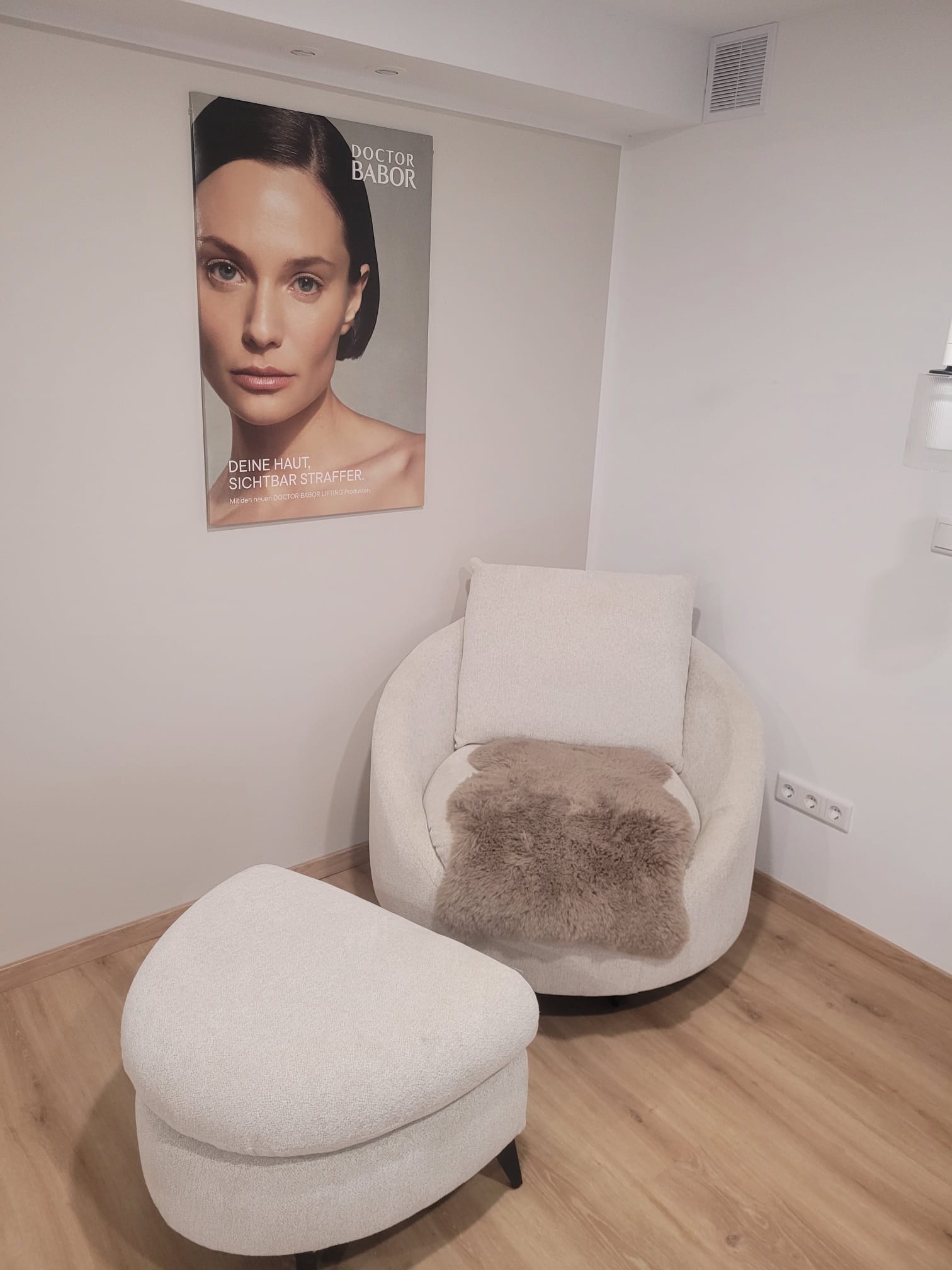 Ruhebereich mit Sessel, Hocker und BABOR-Plakat